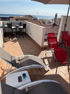 a balcony with chairs and tables on a roof at La Terrazza Bella Sicula in Furci Siculo