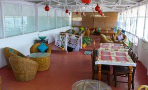 a room with chairs and a table and a room with tables and chairs at Le Clarisse Guest House in Pondicherry