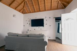 a living room with a couch and a flat screen tv at VV Casa Los Brezos "by AFCVacacional" in Breña Alta