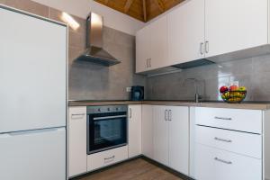 a kitchen with white cabinets and a sink at VV Casa Los Brezos "by AFCVacacional" in Breña Alta