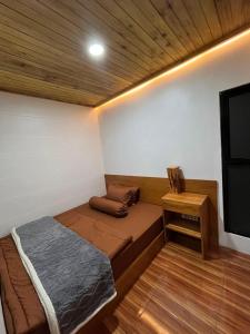 a small room with a bed and a table at Asokabin House in Diyeng +3 photos