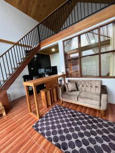 a living room with a couch and a staircase at Asokabin House in Diyeng