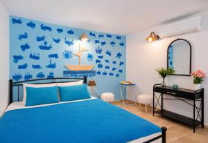 a blue bedroom with a bed and a desk at 4 Seasons Island Suites Athens Airport in Markopoulo