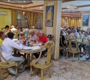 a group of people sitting at tables in a restaurant at Jibreen Hotel in Bahlāʼ +50 photos