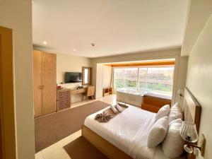 a bedroom with a bed and a large window at DouDou Pyramids View Hotel in Cairo