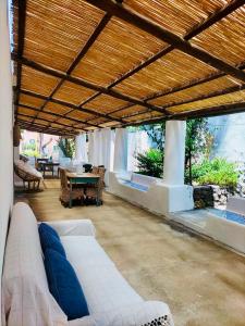 a living room with a white couch and a wooden ceiling at Dépendance Liscio in Filicudi