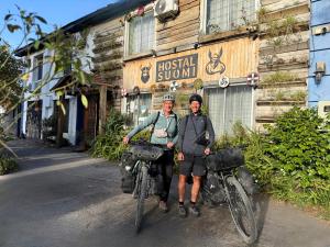 two people on bikes in front of a building at Hostal Suomi in Los Ángeles