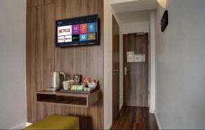 a room with a television on a wall with a table at North-Hotel in Hamburg