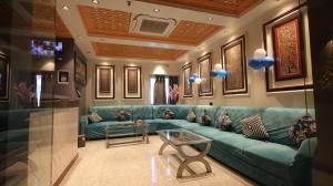 a living room with a blue couch and a table at Hotel Ganesha - residential in Muzaffarpur