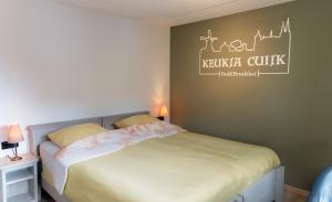 a bedroom with a bed and two tables with lamps at B&B Keukja Cuijk in Cuijk