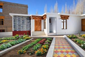 a house with a garden in front of a building at RH Guest House Leh in Leh