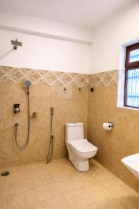 a bathroom with a shower and a toilet and a sink at RH Guest House Leh in Leh