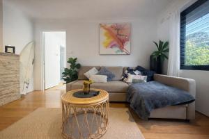 a living room with a couch and a table at Coastal Stay in Cronulla