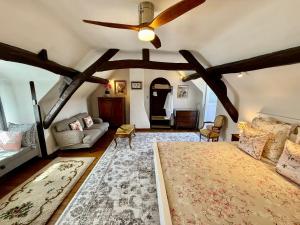 a bedroom with a ceiling fan and a living room at Sans Souci Bed and Breakfast with Luxe Heated Pool in Luzillé