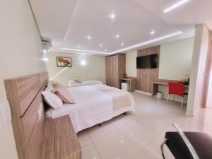 a hotel room with a bed and a desk at Diamante Rosa Palace Hotel in Coromandel