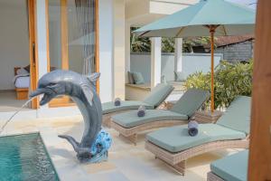 a dolphin statue in the middle of a pool at Dolphin - New luxury rooms in Lovina Centre & near the beach in Lovina