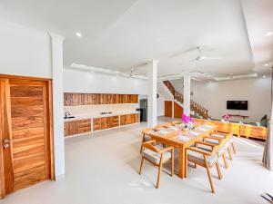 a kitchen and dining room with a wooden table and chairs at Dolphin - New luxury rooms in Lovina Centre & near the beach in Lovina