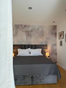 a bedroom with a bed with a concrete wall at Villa Karpa in Pridraga +21 photos