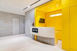 a lobby with a yellow and gray wall at Super Hotel O SAMOTEL in kolkata