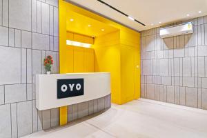 an office lobby with a sign on a yellow wall at Super Hotel O SAMOTEL in kolkata