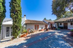 a house with a stone driveway and trees at Cortijo La Hoya in El Bujeo