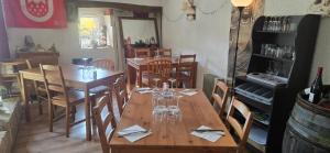 a dining room with wooden tables and chairs with wine glasses at La Bergerie Crenantine in Crenans