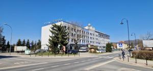a man riding a bike down a street in front of a building at Dom Turysty Sanok in Sanok