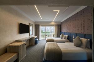 a hotel room with two beds and a television at Pyramids Park Resort Cairo in Cairo