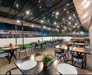 a dining room with tables and chairs and lights at GUARULHOS FLAT CENTER - Apart-Hotel in Guarulhos