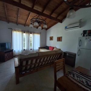 a living room with a couch and a refrigerator at Cabañas del Gordo in Mar del Plata