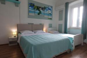 a bedroom with a large bed and a window at Red blue with private parking and Gray blue apartment in Pula