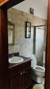 a bathroom with a toilet and a sink at Blasto & Esita Cottages in Bunamwaya +7 photos