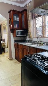 a kitchen with a stove top oven next to a sink at Blasto & Esita Cottages in Bunamwaya