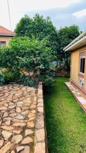 a yard with a stone path next to a house at Blasto & Esita Cottages in Bunamwaya