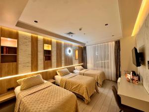 a hotel room with two beds and a television at Lavender Inn Hotel in Arnavutköy +159 photos