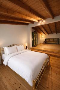 a large white bed in a room with wooden floors at Melitta Villa in Ágios Ioánnis +21 photos