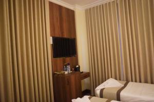 a hotel room with two beds and a television at فندق رؤى الاندلس البلاتيني - Roaa Alandalus Platinum Hotel in Medina