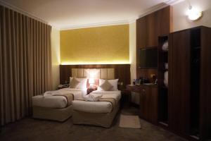 a hotel room with two beds and a television at فندق رؤى الاندلس البلاتيني - Roaa Alandalus Platinum Hotel in Medina +17 photos