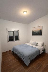 a bedroom with a bed and two windows at Refugio del bosque - Casa con jacuzzi descanso en Piriapolis in Piriápolis