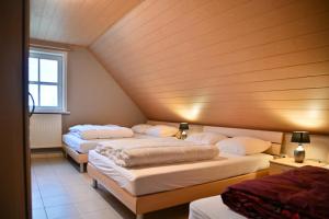 three beds in a room with a wooden ceiling at 't Ooievaarsnest in Veurne