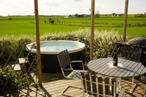 a hot tub on a deck with a table and chairs at 2 Bedroom Cottage With Spa Accommodations in Glemmingebro