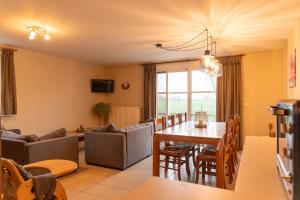 a living room with a table and a dining room at 't Ooievaarsnest in Veurne