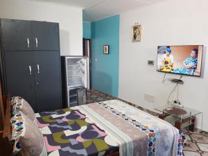 a room with a bed and a flat screen tv at Résidence BEDEL in Yamoussoukro