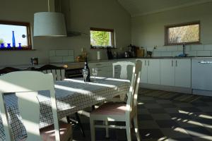 a kitchen with a table and chairs and a table and a kitchen at 2 Bedroom Cottage With Spa Accommodations in Glemmingebro