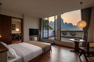a hotel room with a large bed and a balcony at Hidden Valley Hotel-- New Hotel,A Hidden Gem,Serene Sanctuary,Exclusive Location,Swimming Pool & Cycling Route,Attraction Tickets Serivce in advance,Affordable Luxury,Best Karst Mount View in Yangshuo in Yangshuo