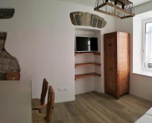 a living room with a television and a table and chairs at Casa Nonna Giovanna in Tesero