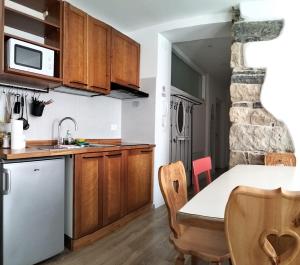 a kitchen with wooden cabinets and a table with a sink at Casa Nonna Giovanna in Tesero