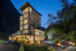 a large building with lights on it at night at Hidden Valley Hotel-- New Hotel,A Hidden Gem,Serene Sanctuary,Exclusive Location,Swimming Pool & Cycling Route,Attraction Tickets Serivce in advance,Affordable Luxury,Best Karst Mount View in Yangshuo in Yangshuo