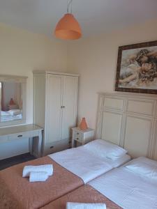 a bedroom with two beds and a desk and a mirror at Korali in Skiros