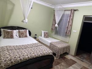 a bedroom with a bed and a window at Blasto & Esita Cottages in Bunamwaya